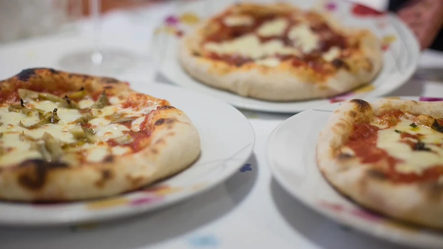 Pizzas de style napolitain à la corniche gonflée et alvéolée servies sur des assiettes