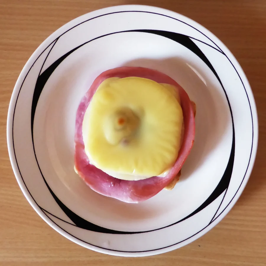 Toast Hawaii au jambon, ananas et fromage fondu servi sur une assiette