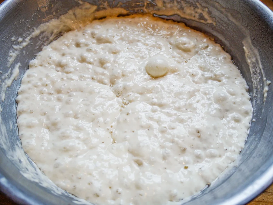 Préferment liquide couvert de bulles dans un saladier après une nuit de fermentation