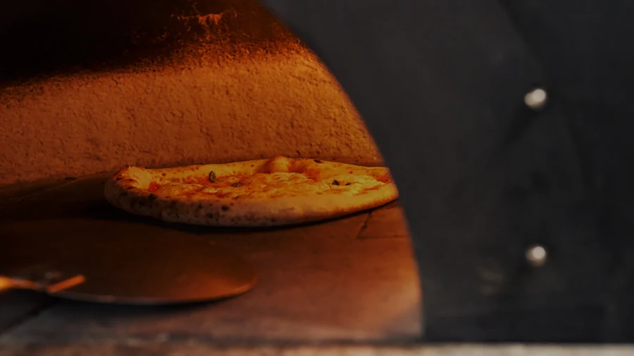 Pizza en cours de cuisson dans un four à bois