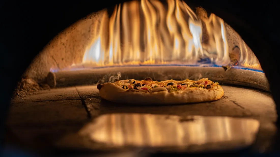 Pizza enfournée sur une pierre