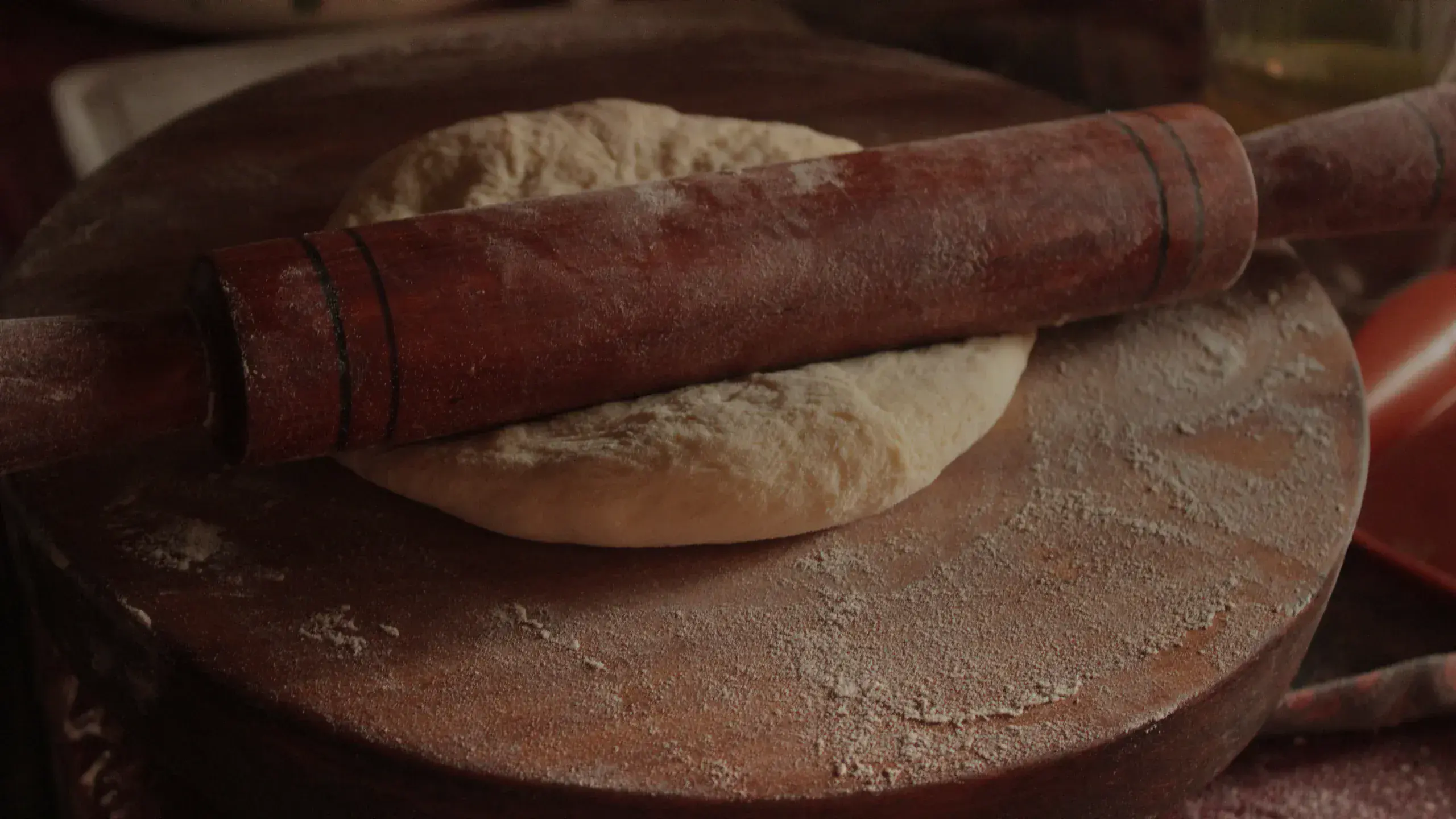 Pâte à pizza étalée au rouleau sur un plan fariné